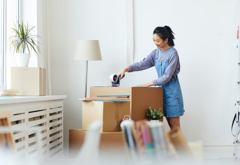 Woman packing belongings in boxes.